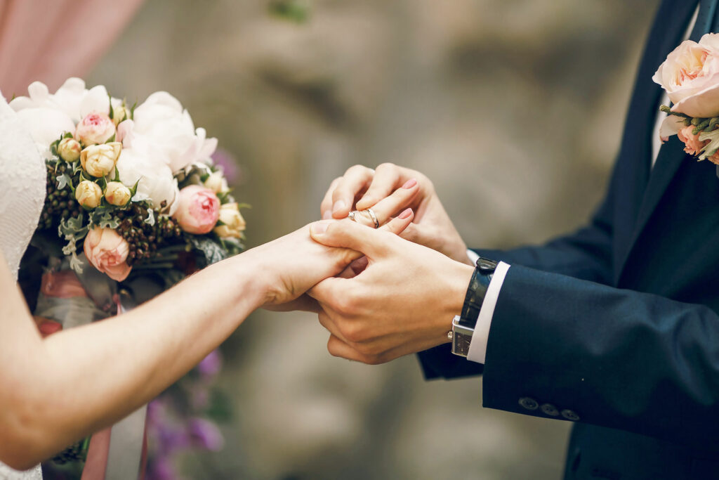 Groom putting a ring on the bride's finger